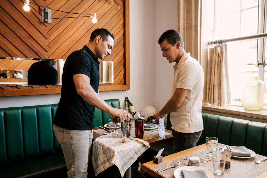 couple making cocktails during their november engagement session at jockey hollow bar & kitchen in new jersey