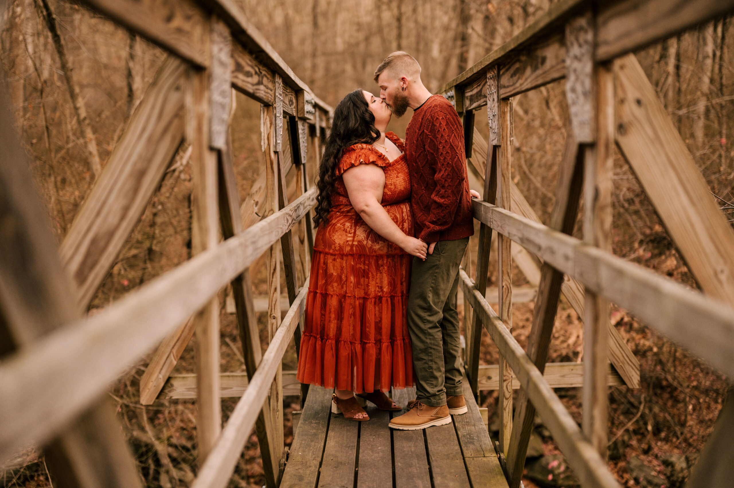 Couple kisses on bridge at Long Pond Iron Works in Ringwood New Jersey