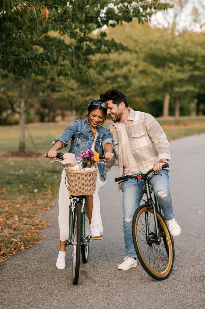 couple riding on bikes through liberty state park during engagement session