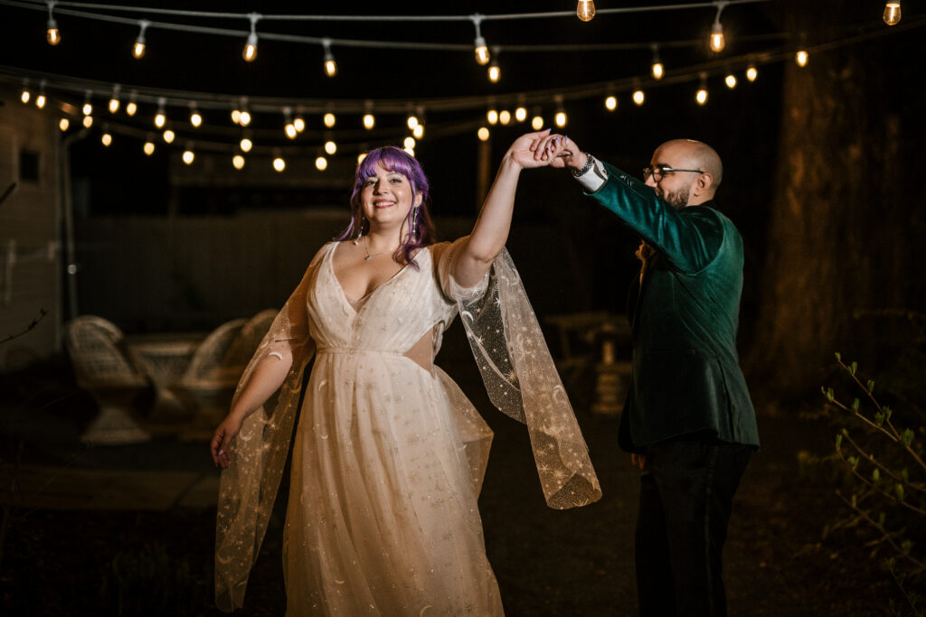 bride and groom having their last dance outside under the string lights