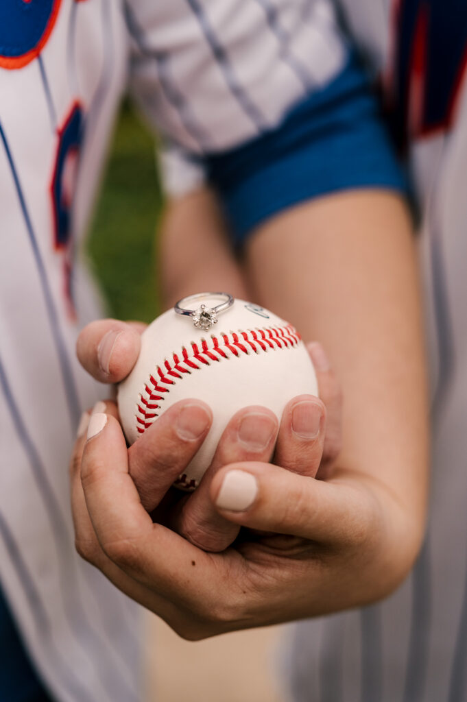 close up photo of engagement ring on top of a baseball during couple's Citi Field engagement session 