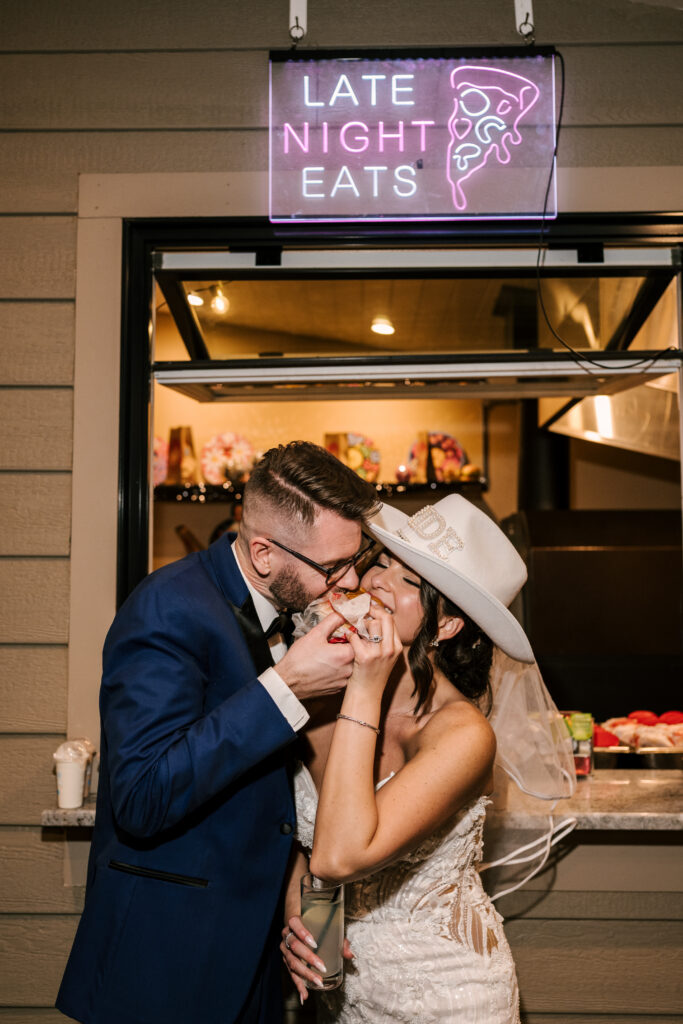 bride and groom taking a bite of their late night treats at the end of their nj spring wedding