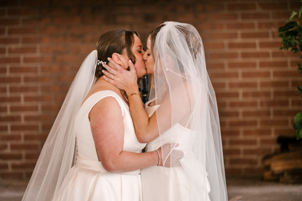 brides first kiss at wedding ceremony at stone house at stirling ridge in warren nj 
