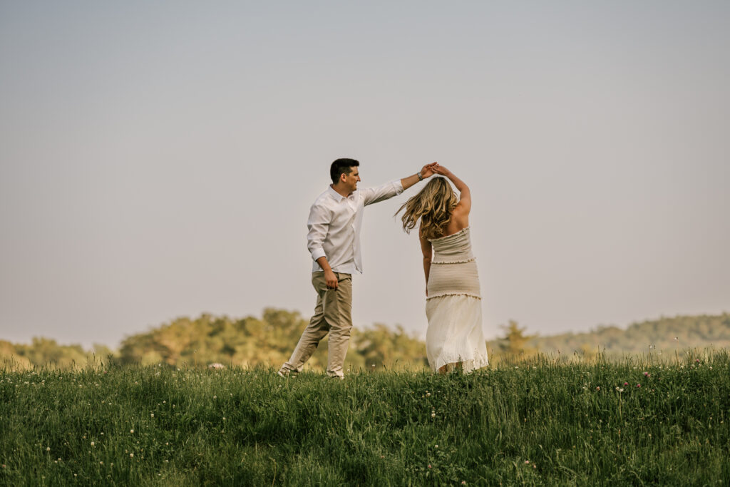 couple dancing in a lush green field at wawayanda state park during their nj june engagement session
