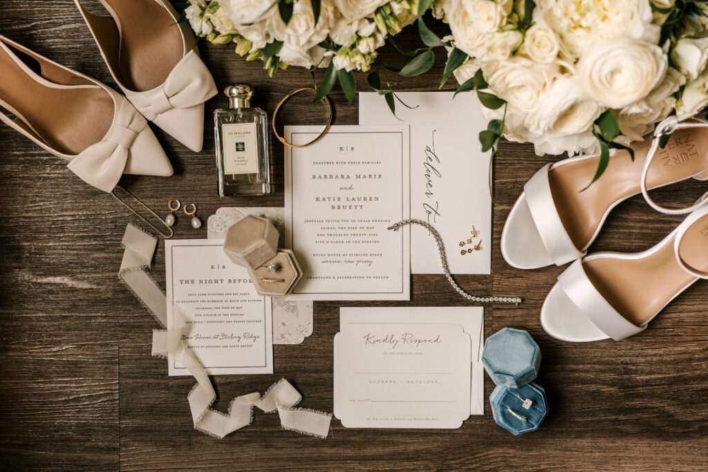 flat lay photo of wedding invitation, bride's shoes, ring box, perfume, flowers and other details of their nj wedding 