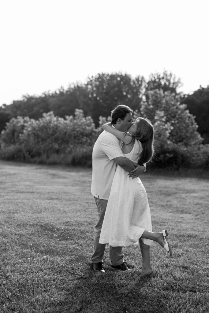dreamy black and white photo of couple kissing in the field at Natirar in Peapack NJ