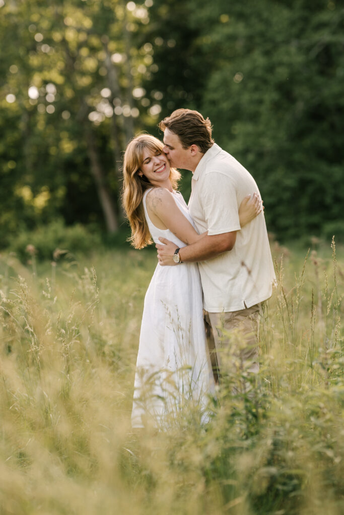 Engaged couple embraces in the field at Natirar in Peapack, Gladstone NJ for their June engagement session.