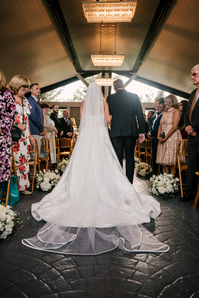 bride and her father walking down the aisle during park loft wedding in june